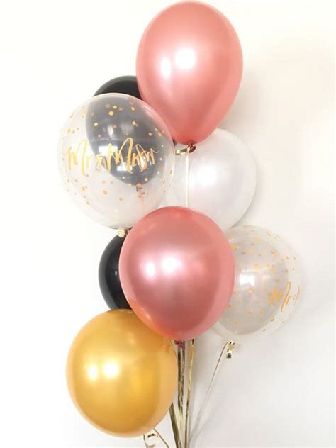 A Bunch Of Balloons With The Word Happy On Them In Gold White And Black
