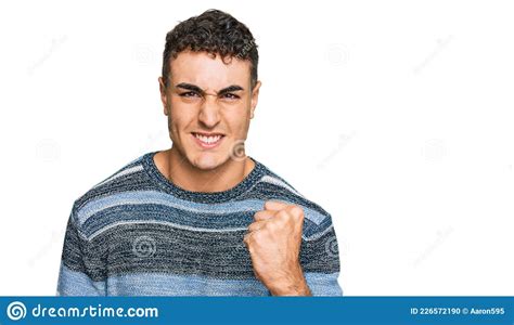 Hispanic Young Man Wearing Casual Clothes Angry And Mad Raising Fist