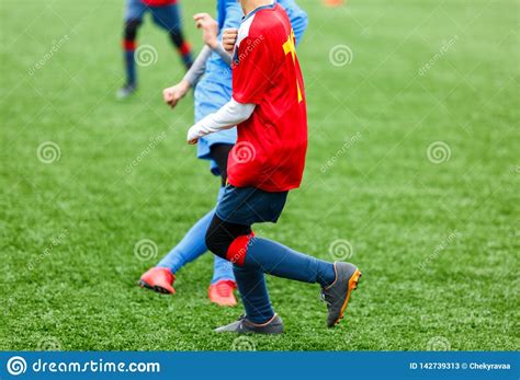 Football Training For Kids Boys In Blue Red Sportswear On Soccer Field
