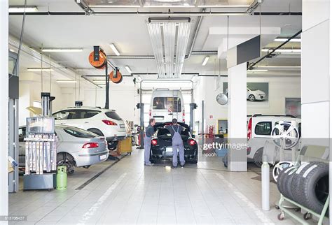 Auto Repair Shop With Car Serviced By Mechanics High Res Stock Photo