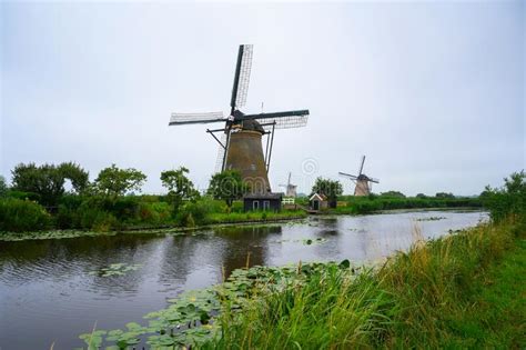 historic windmills and a river flowing by in kinderdijk netherlands stock image image of