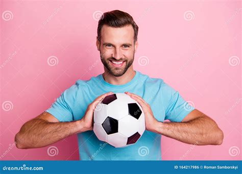 Photo Of Cheerful Positive Man Football Player Smiling Toothily Holding
