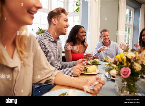 Friends At Home Sitting Around Table For Dinner Party Stock Photo Alamy