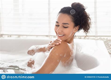 Lovely Millennial Woman Lying In Bathtub With Foam Enjoying Bubble