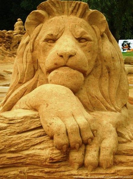 a sand sculpture of a lion with its paw on his chest
