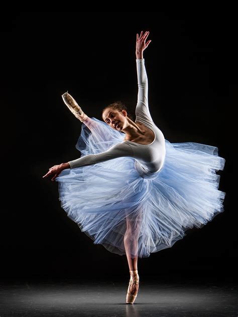 The Ballerina Is Wearing A White Tutu And Blue Skirt