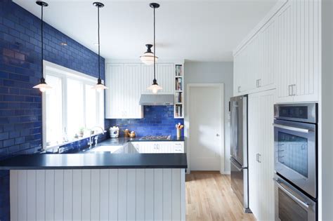 The rustic decor above the stove and tin tiles on the ceiling add retro touches that are complemented by bold blue cabinets. Kitchen Color: 15 Beautiful Blue Backsplashes