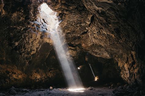 Light Beams Pierce Through The Dark Volcanic Cave Photograph By Cavan