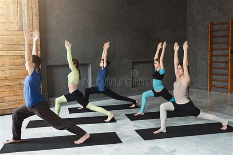 Young Women And Men In Yoga Class Doing Stretching Exercises Stock