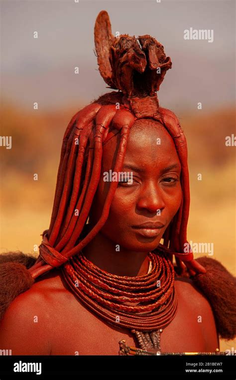 Himba Woman With Traditional Ornaments Standing By The Road Going To