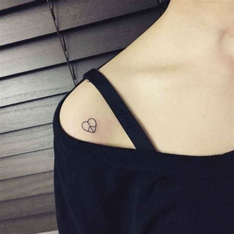 A Woman With A Small Heart Tattoo On Her Shoulder