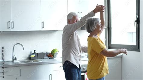 Joyful Active Old Retired Romantic Couple Dancing Laughing In Living Room Happy Middle Aged