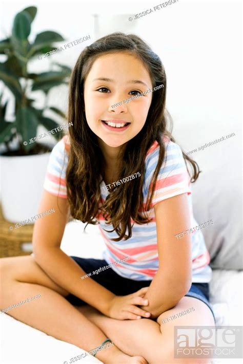 Portrait Of Content Girl 10 11 Sitting With Legs Crossed Stock Photo
