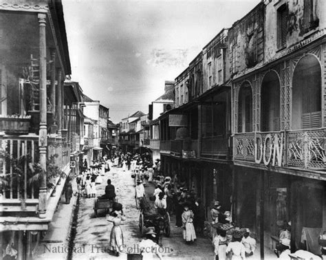 an old black and white photo of people walking down the street in front of buildings