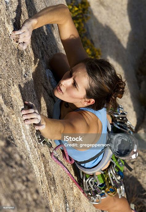 Female Rock Climber Clinging To A Cliff Stock Photo Download Image