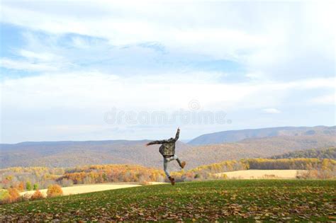 Man Jumping Into Autumn Leaves On A Hill Stock Image Image Of Wild
