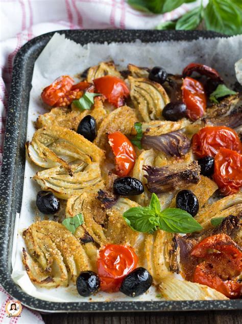 A Dish With Olives Tomatoes And Onions In It Sitting On A Table Next