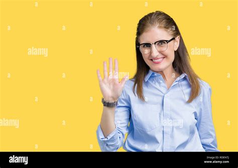 beautiful middle age mature business woman wearing glasses over isolated background waiving