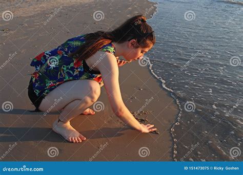 Un Adolescente Scrive Sulla Sabbia Nella Spiaggia Immagine Stock