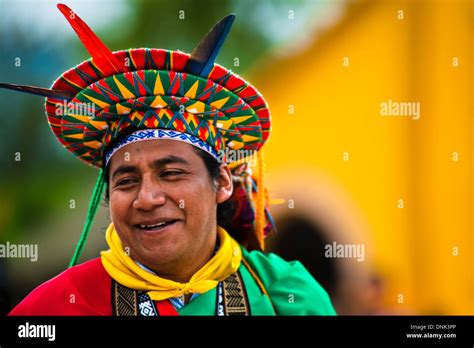 un nativo de la tribu kamentsá vistiendo coloridos sombreros y demás tocados sonríe durante el