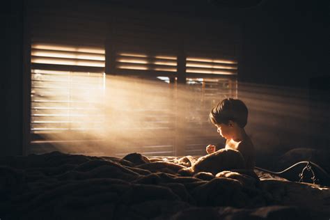Photo Of Boy Sitting On Bed With Light Shining In Windows By Amy Shire