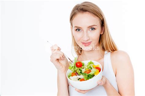 Elegant Lady Enjoying A Healthy Salad On A White Backdrop Royalty Free