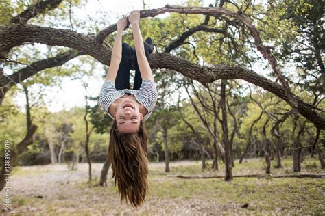 Foto Stock Woman Hanging Upside Down From Tree Branch Adobe Stock
