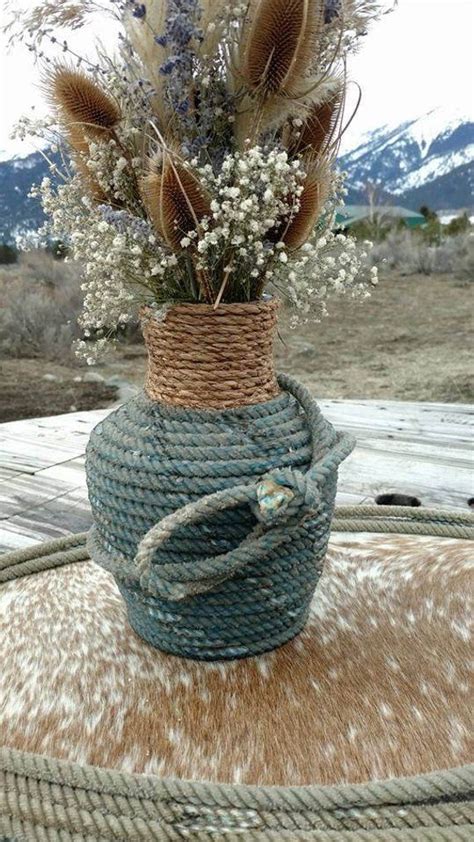 A Rope Wrapped Vase With Dried Flowers In It