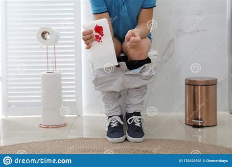 Boy Holding Toilet Paper With Blood Stain In Rest Room Hemorrhoid