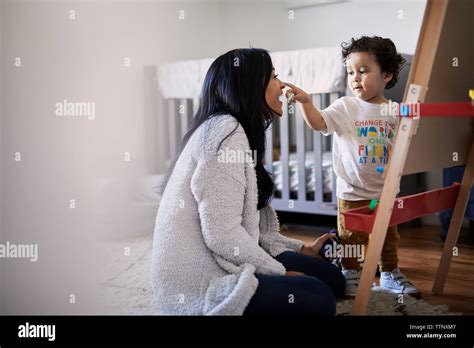 Cute Playful Son Touching Mothers Nose While Drawing On Canvas At Home