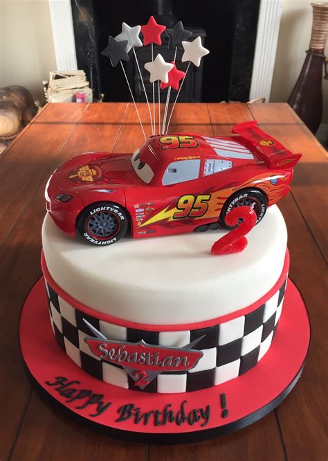 A Birthday Cake With A Red Race Car On Top And Stars In The Air Above It