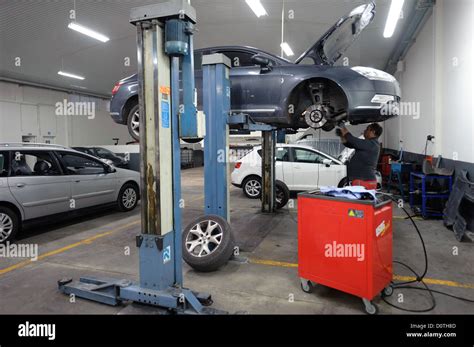 Car Mechanic Checking A Car Raised On A Hydraulic Lift Stock Photo Alamy