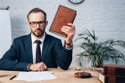Premium Photo Selective Focus Of Bearded Lawyer In Glasses Holding Book In Office