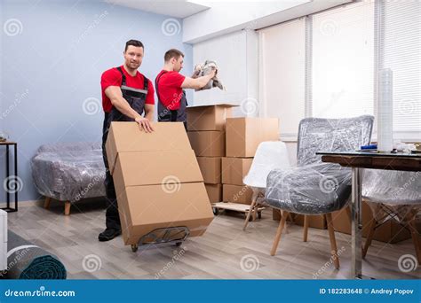 Movers Packing The Products In The Living Room Stock Photo Image Of