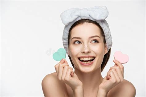 Girl Holding Heart Shaped Cosmetic Sponges While Looking Away Isolated