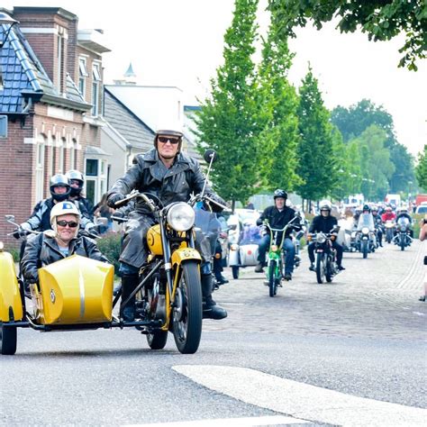 A Group Of Bikers Riding Down The Street On Their Motorcycles With