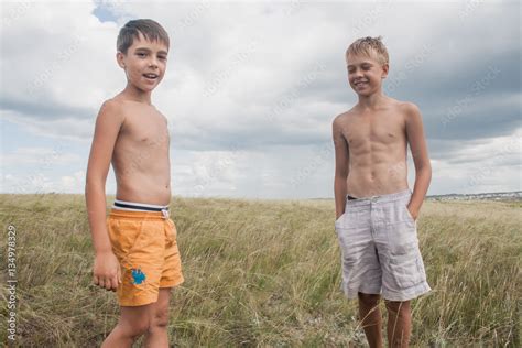 Stockfoto Young Boys Standing In A Field Boys In Shorts Boys Stand In