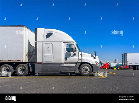 Long Haul Big Rig White Semi Truck Tractor Stand On Truck Stop Parking