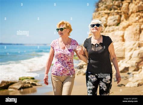 Two Elderly Women Are Walking Along The Rocky Shore Stock Photo Alamy