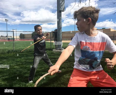 Boys Sword Fight Next To Ball Field Stock Photo Alamy