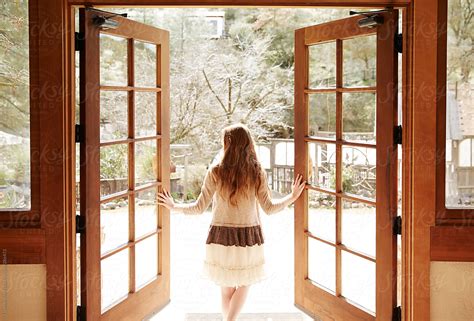 Woman Walking Through And Opening Doors To The Outside By Stocksy Contributor Trinette Reed