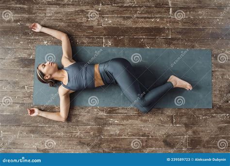 Top View Woman Practicing Yoga Lying On Mat In The Gym On The Floor