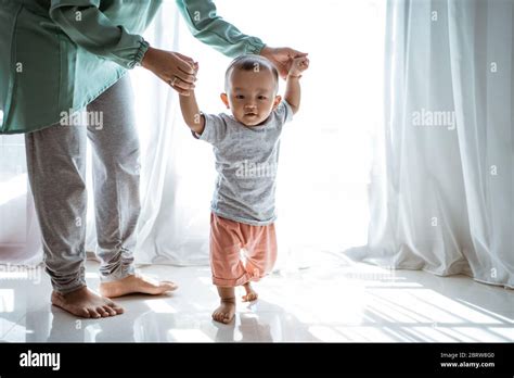 Baby First Step Mother Help Her Baby Walking At Home Stock Photo Alamy