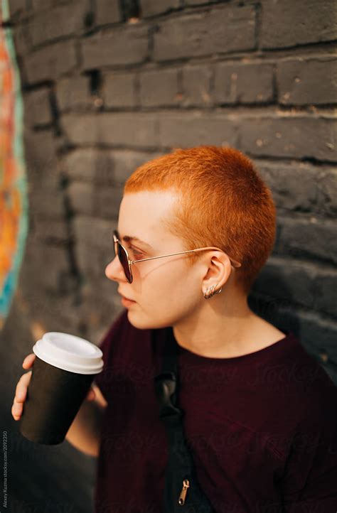 Young Androgyne Woman With Short Red Hair Drinking Coffee On Str By