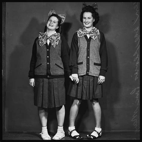 Two Women Standing Next To Each Other In Front Of A Black And White Background
