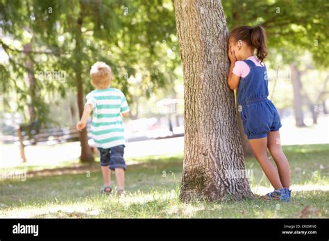 Two Children Playing Hide And Seek In Park Stock Photo Alamy