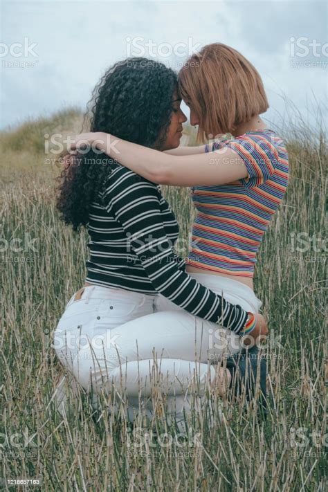 Two Lesbian Women Kissing On Top Of Each Other One Girl Is Latino And