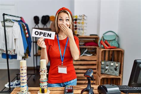 Young Caucasian Woman Holding Banner With Open Text At Retail Shop Covering Mouth With Hand