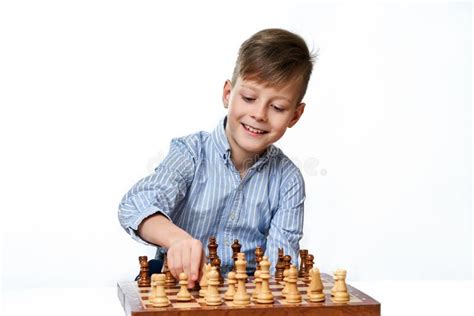 Cute Smiling Caucasian Boy Shows Chess Pieces On A Chessboard Stock