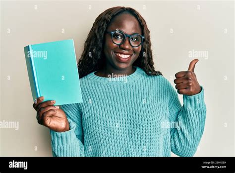African Young Woman Reading A Book Wearing Glasses Smiling Happy And